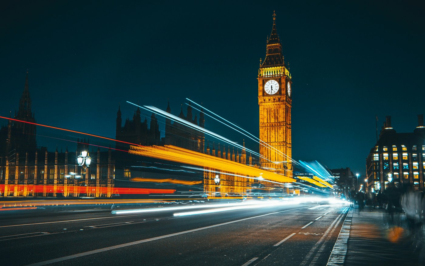 Big Ben and the Houses of Parliament at night, with traffic light trails on Westminster Bridge