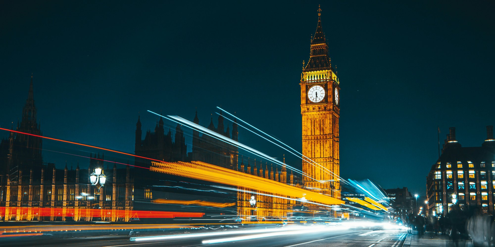 Big Ben and the Houses of Parliament at night, with traffic light trails on Westminster Bridge