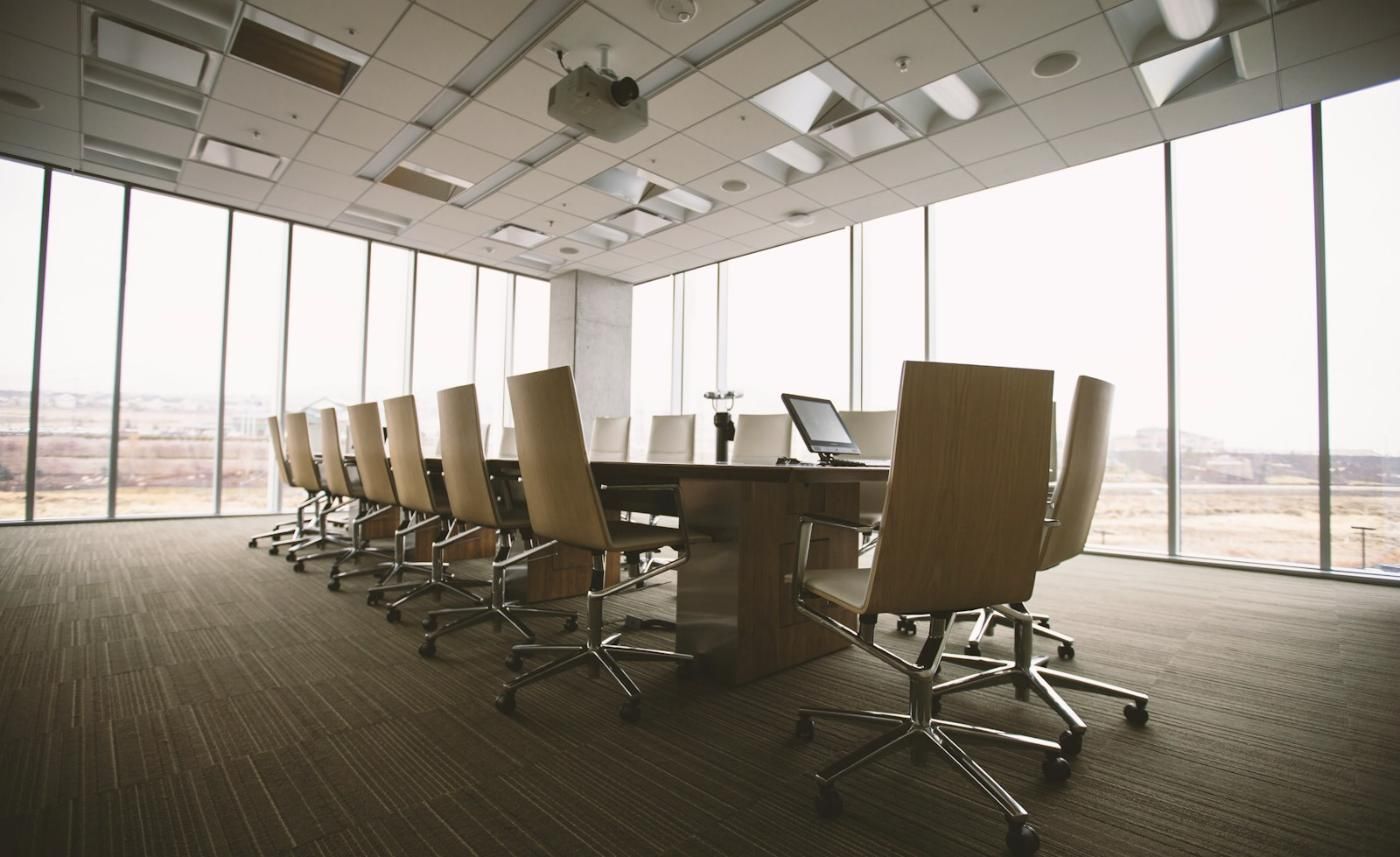 An empty boardroom with a long table and chairs